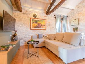 a living room with a white couch and a brick wall at Apartment Botra Maria by Interhome in Sveti Petar u Šumi +20 photos