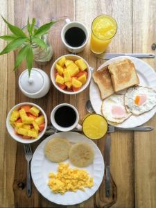 里奥阿查Bona Vida Hotel的一张木桌,上面放着早餐食品和饮料