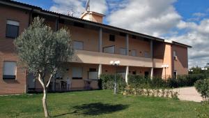 un edificio con un árbol delante de él en RTA Martin Pescatore, en Grosseto