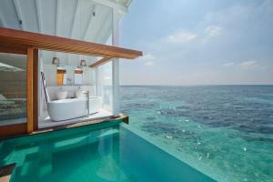 a swimming pool with a tub in the ocean at Kandolhu Maldives in Himandhoo 