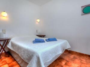ein weißes Zimmer mit einem Tisch und blauen Handtüchern darauf in der Unterkunft Apartment Sant Carles by Interhome in Llança
