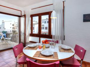 a dining room with a table and chairs and a window at Apartment Sant Carles by Interhome in Llança