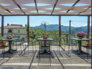 a patio with tables and chairs and a view of mountains at Holiday Home Del Regolo by Interhome in Molazzana