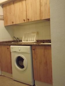 a kitchen with a washing machine and a sink at APCOSTAS - Habitat Playa Romana in Alcossebre