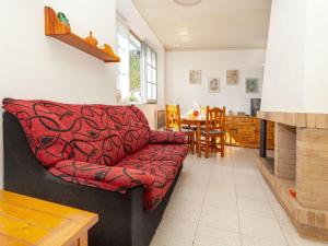 a living room with a red couch and a table at Apartment La Rectoria by Interhome in La Vall de Santa Creu