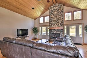 a leather couch in a living room with a stone fireplace at Tranquil 6-Acre Escape with Hot Tub and Mtn Views! in Swannanoa