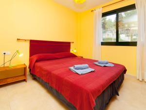 a bedroom with a red bed with towels on it at Apartment Escorxador by Interhome in L'Escala
