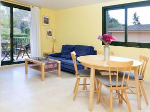 a living room with a table and a blue couch at Apartment Escorxador by Interhome in L'Escala