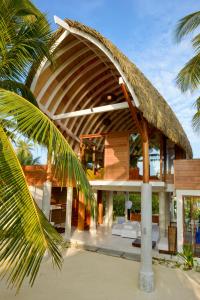 a house on the beach with a straw roof at Kandolhu Maldives in Himandhoo 
