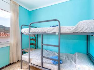 2 literas en una habitación con una pared azul en Apartment Villa Cordoba-2 by Interhome, en Port de la Selva