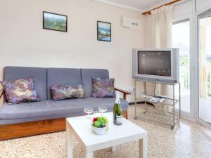 sala de estar con sofá azul y TV en Apartment Villa Cordoba-2 by Interhome, en Port de la Selva