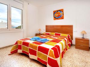 Un dormitorio con una cama colorida y una ventana en Apartment Villa Cordoba-3 by Interhome, en Port de la Selva