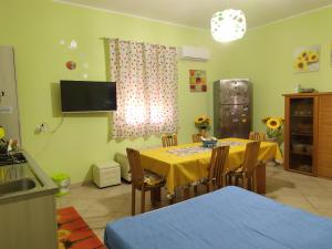 eine Küche mit einem Tisch und einem gelben Tischtuch in der Unterkunft Serenity House in Scordia
