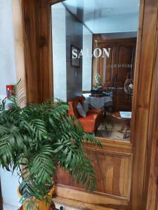 a living room with a red couch and a mirror at Hôtel La Montagne Fleurie in Barèges