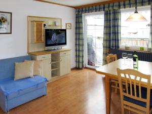 ein Wohnzimmer mit einem TV und einem Esstisch in der Unterkunft Apartment Margit - HAE170 by Interhome in Haus im Ennstal