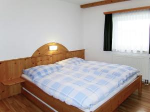 Schlafzimmer mit einem Bett mit einem Kopfteil aus Holz und einem Fenster in der Unterkunft Apartment Margit - HAE170 by Interhome in Haus im Ennstal
