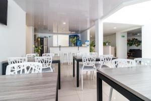 a dining room with white chairs and tables at Hotel Federman Park Bogota in Bogotá