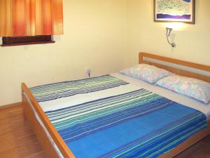 Schlafzimmer mit einem Bett mit einer blauen und weißen Bettdecke in der Unterkunft Apartment Mile-1 by Interhome in Grebaštica