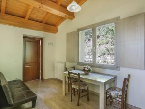 ein Esszimmer mit einem Tisch, Stühlen und einem Fenster in der Unterkunft Apartment Capanna - CNG175 by Interhome in Magnano