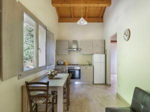 eine Küche mit einem Tisch und Stühlen sowie einem Kühlschrank in der Unterkunft Apartment Capanna - CNG175 by Interhome in Magnano