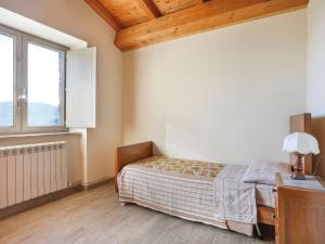 Schlafzimmer mit einem Bett, einem Schreibtisch und einem Fenster in der Unterkunft Apartment Capanna - CNG175 by Interhome in Magnano