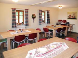 une salle à manger avec des tables en bois et des chaises rouges dans l'établissement Holiday Home Kreuzbuche by Interhome, à Viechtach