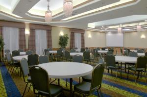 a conference room with tables and chairs and a screen at Holiday Inn Express & Suites Galveston West-Seawall in Galveston