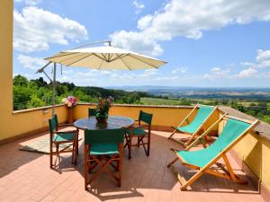 a patio with a table and chairs and an umbrella at Holiday Home Villetta nel Verde by Interhome in Montaione