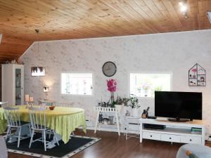 un salon avec une table et une télévision dans l'établissement Holiday Home Rødehuset - FJH670 by Interhome, à Gjelland