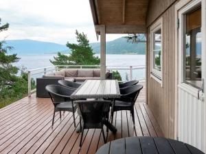 a wooden deck with a table and chairs on it at Holiday Home Lyktvorholmen - FJS618 by Interhome in Hopperstad