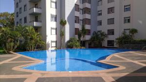 a swimming pool in front of a building at Garden's Apartment in Funchal