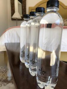 tres botellas de agua sentadas en una mesa de madera en Fleur de Lis Guesthouse en Krugersdorp