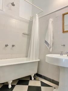 a white bath tub sitting next to a white sink at Hotel Chemin in Buenos Aires