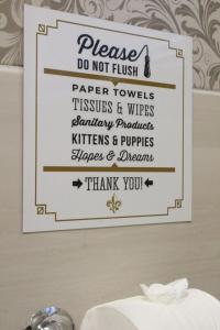 un panneau indiquant qu'il ne faut pas laver les serviettes et les paquets en papier dans l'établissement Fleur de Lis Guesthouse, à Krugersdorp