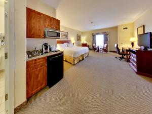 une chambre d'hôtel avec un lit et une cuisine dans l'établissement Holiday Inn Express Hotel & Suites - Edmonton International Airport by IHG, à Nisku