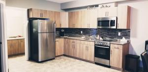 a kitchen with wooden cabinets and a stainless steel refrigerator at Alberta Beach Inn and Suites in Albert Beach (Alberta)