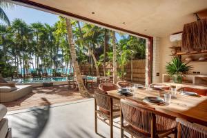 a dining room with a table and chairs on a patio at Privada Soliman Bay villa pets welcome! in Tulum