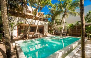 a swimming pool with palm trees and a house at Privada Soliman Bay villa pets welcome! in Tulum