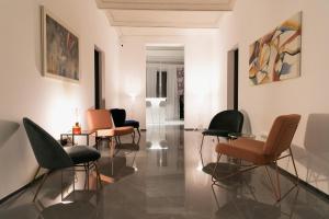 salon z krzesłami i obrazami na ścianach w obiekcie WeLive w mieście Carpi