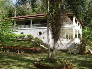 een wit huis met een palmboom ervoor bij Sitio Mogi das Cruzes in Taiaçupeba