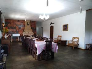 ein Esszimmer und eine Küche mit einem Tisch und Stühlen in der Unterkunft Sitio Mogi das Cruzes in Taiaçupeba