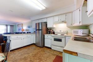 a kitchen with white cabinets and a stainless steel refrigerator at Bayspot L in Ocean City
