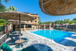 a swimming pool with chairs and an umbrella at Villa Yannis in Kato Korakiana