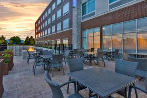 a patio with tables and chairs in front of a building at Holiday Inn Express & Suites - Grand Rapids Airport - South by IHG in Grand Rapids