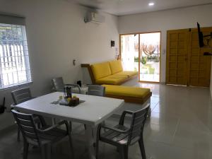 sala de estar con mesa y sofá amarillo en Bahia Tropical Sandia Kiwi Piña, en Coveñas