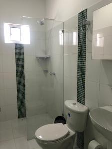a bathroom with a toilet and a shower and a sink at Bahia Tropical Sandia Kiwi Piña in Coveñas