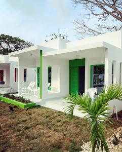 una gran casa blanca con una puerta verde en Bahia Tropical Sandia Kiwi Piña, en Coveñas