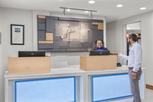 two people standing at a counter in a office at Holiday Inn Express & Suites - Hardeeville-Hilton Head, an IHG Hotel in Hardeeville