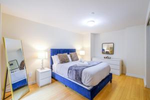 1 dormitorio con cama azul y espejo en Evonify Stays - Theatre District Apartments, en Boston