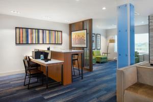 a lobby with a desk with a computer and chairs at Holiday Inn Express & Suites - Bourbonnais East - Bradley by IHG in Bourbonnais +58 photos